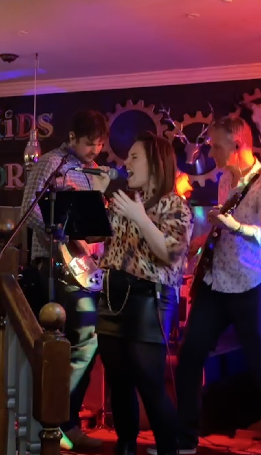 Vocalist in full flow on stage at a pub venue