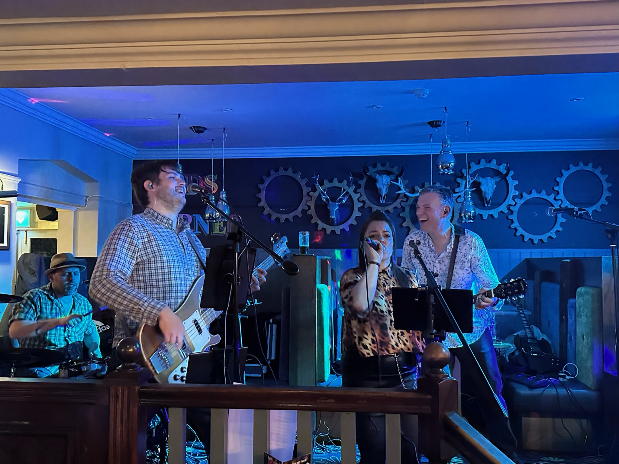 Trinity Road full band in high spirits on stage under blue lighting